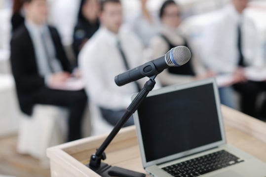 business laptop and microphotone at podium on seminar conference education.jpeg