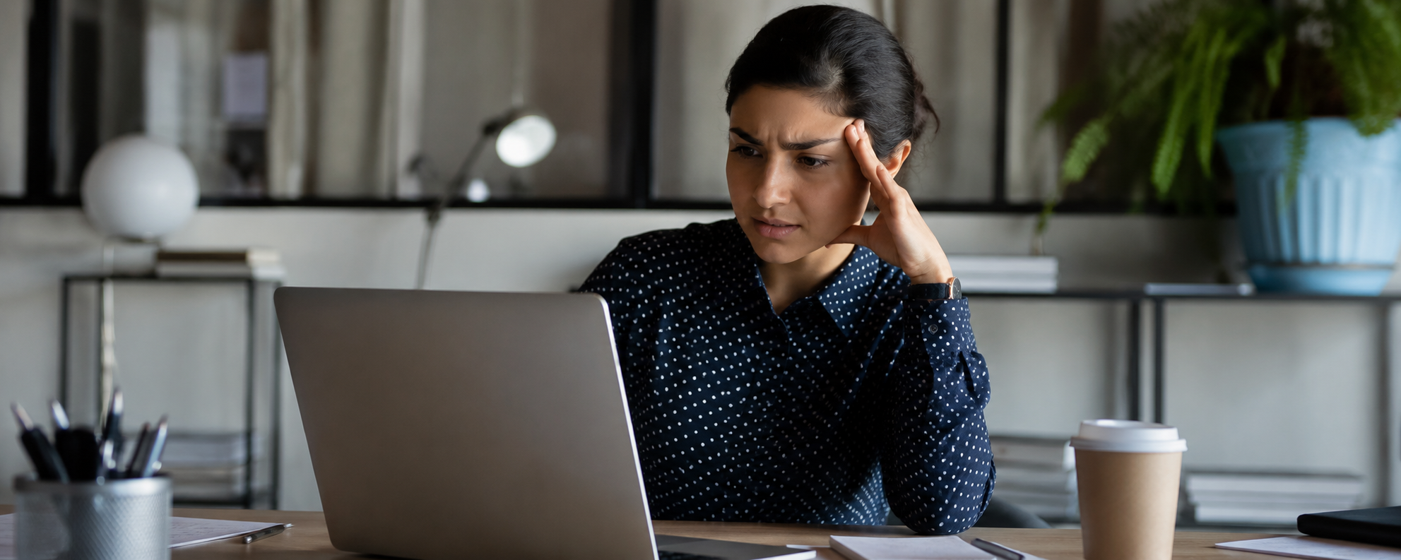 Internal communications manager reviewing out of date employee engagement survey data on a laptop