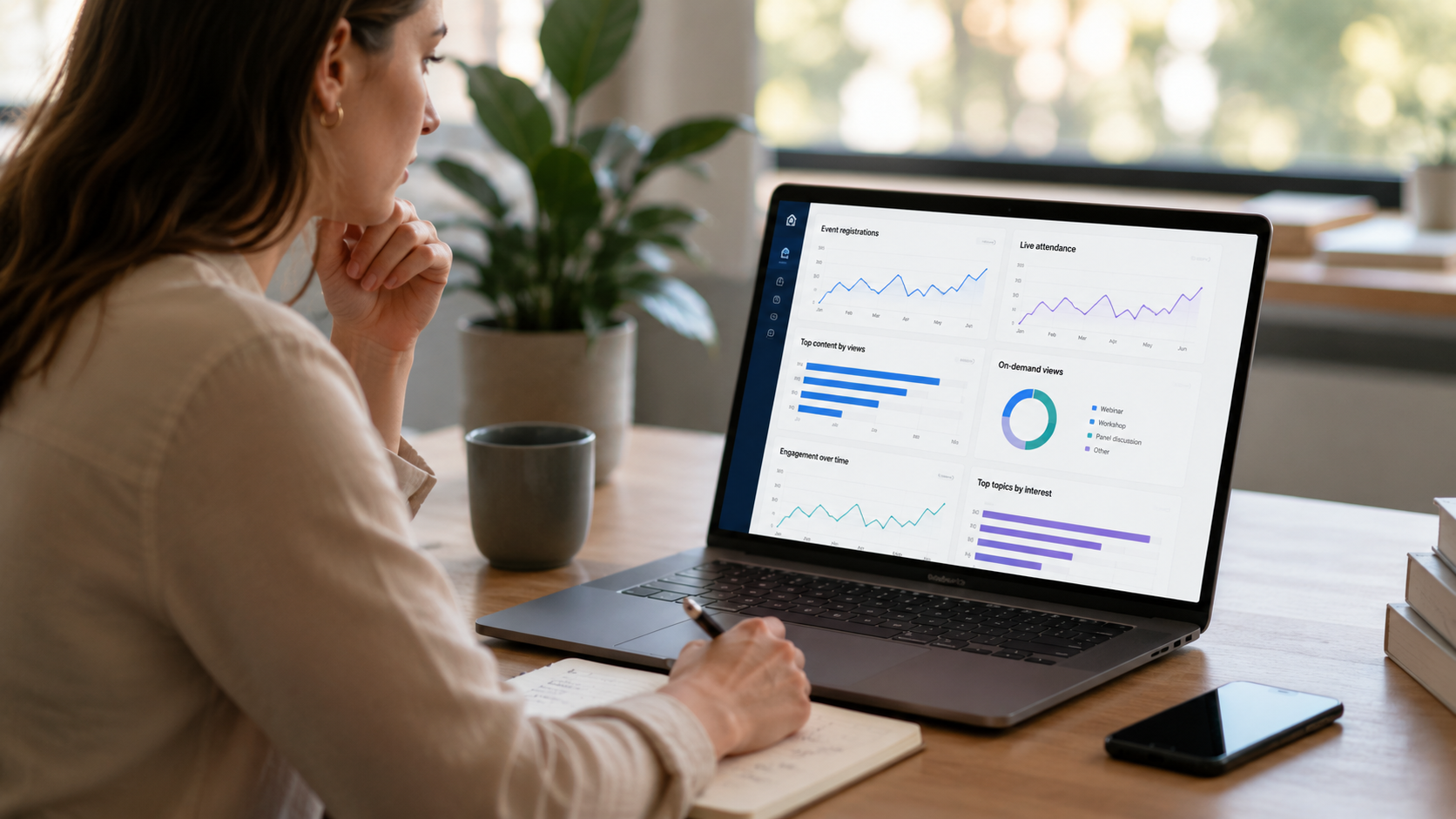 A professional reviewing performance dashboards and engagement data on a laptop in a modern workspace, using analytics and insights to understand audience behaviour and make informed decisions about future content and events.