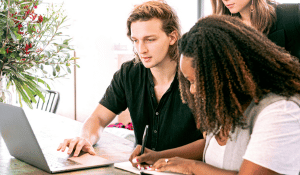 man-working-on-laptop-while-woman-takes-notes